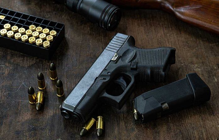 1439841965 featured image Handgun with ammunition magazine and rifle on wooden table