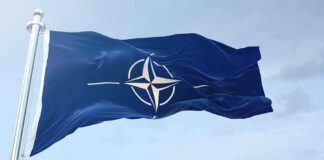 NATO flag waving against blue sky