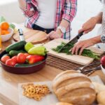 People preparing fresh vegetables in kitchen