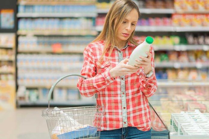 1031614558 featured image woman examining a bottle of milk