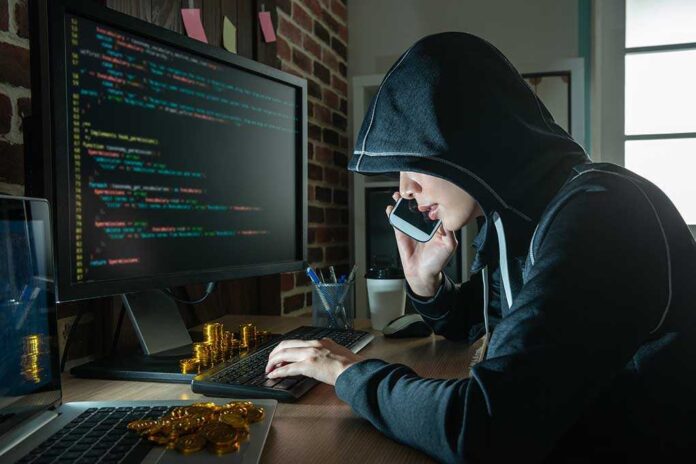 1166668681 featured image Hacker in hood using computer and phone analyzing cod