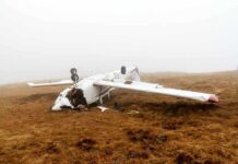 Overturned crashed airplane on grassy field