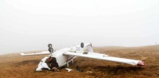 Overturned crashed airplane on grassy field