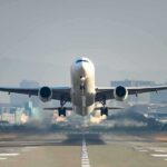Airplane taking off from runway in urban area
