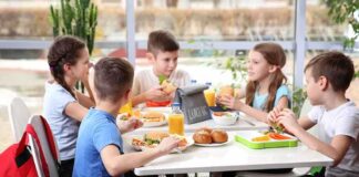Kids eating lunch together at a table.
