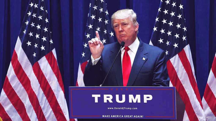 1456399979 Man speaking at podium with USA flags behind him