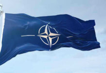 NATO flag waving against blue sky