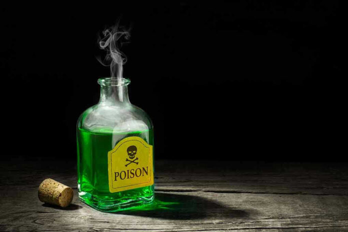 720129613 Green poison bottle with cork on wooden surface