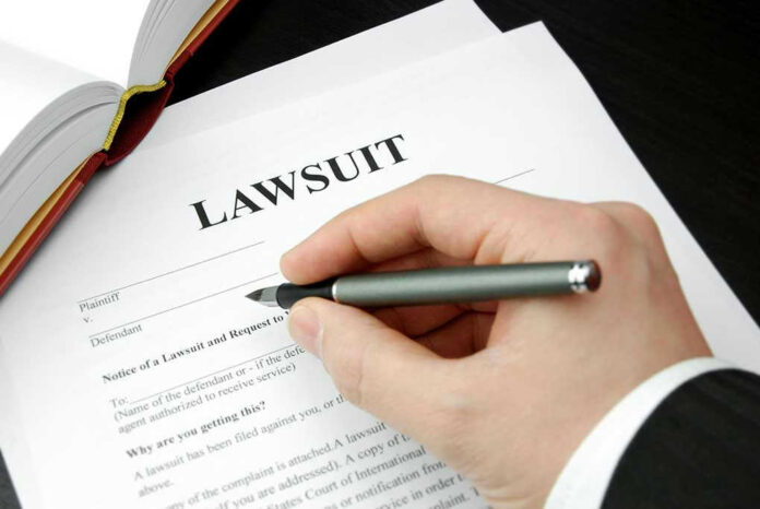 93505333 Hand holding pen, filling out lawsuit form