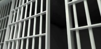 Closeup view of metal prison bars in a dark environment