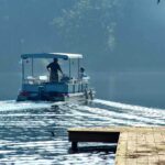 Fishing Crisis Looms: Trump’s Next Big Move? Two people on a boat navigating a misty lake