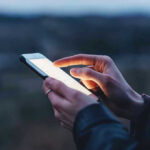 Person using a smartphone at dusk.