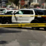 Planned Mass Attack THWARTED – 200 Bombs Found! Police tape blocking street with patrol cars.