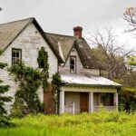 Renovation Horror: 100-Year-Old Home’s Shocking Secrets! An abandoned house surrounded by overgrown grass and trees