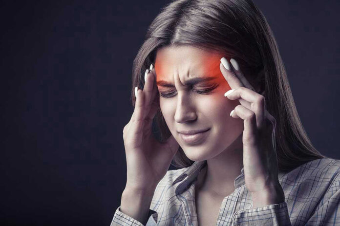 Woman holding head experiencing intense headache or migraine