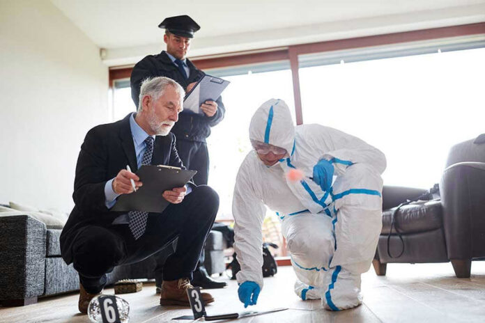 Forensic team examining evidence at a crime scene indoors.