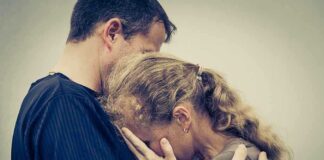 A couple embracing, with one partner comforting the other who is in distress