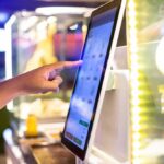 Chipotle UNLEASHES Bizarre New Menu Item A hand interacting with a touchscreen menu in a restaurant