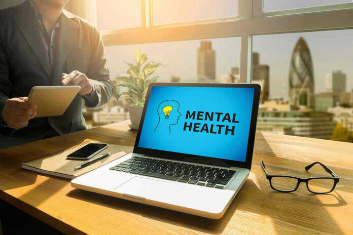 Laptop displaying Mental Health screen in an office.