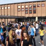 Students Defy ICE in Capitol Showdown A large group of students socializing outside a school building