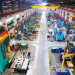 TRUMP’s Tariff Triumph: John Deere’s Historic Move Aerial view of a large industrial workshop filled with various machinery and equipment