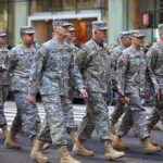 Trump’s SHOCKING Troop Withdrawal: What’s Next? Group of soldiers marching in a military parade on a city street