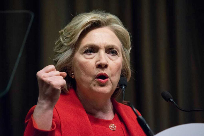 Person speaking passionately at a podium, wearing red jacket.