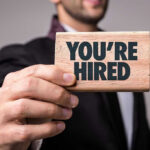 Jobs Report Shocks: Private Sector Booms Person holding a Youre Hired sign.