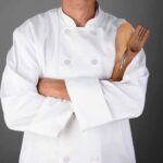 PAM Cooking Spray DESTROYS Man’s Lungs Completely A chef in a white uniform holding wooden cooking utensils with crossed arms