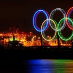 Olympic Shock: USA Beats Canada in Overtime Illuminated Olympic rings displayed at night over a harbor
