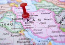 Red pushpin marking Iran on a map.