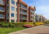Modern apartment buildings with balconies and landscaped gardens on a sunny day