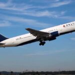 Delta Airlines airplane taking off against a blue sky