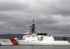 A U.S. Coast Guard ship docked under cloudy skies