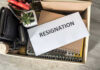 Woke Mayor Immediately Resigns Just Months After Swearing In Envelope labeled RESIGNATION atop office supplies in box.