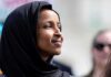Ilhan Omar Can’t Answer Simple Question Amid Fraud Investigation Woman wearing a black hijab looking thoughtfully during an outdoor event
