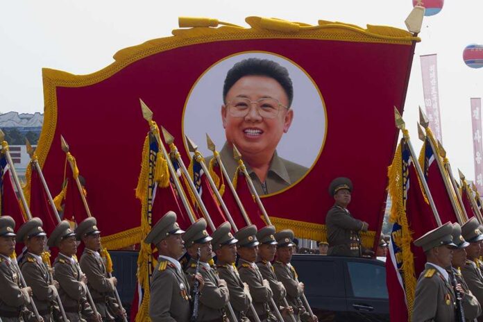 Military parade featuring soldiers and a large banner of Kim Il-sung