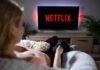 Netflix SUED – Caught Doing THIS To Kids! Person watching Netflix on a TV while holding a bowl of popcorn
