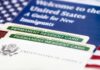 A guide for new immigrants alongside permanent resident cards and an American flag