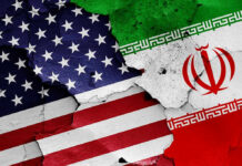 Iran KICKED OUT U.S – World Cup Stunner! Cracked American and Iranian flags painted on a wall.