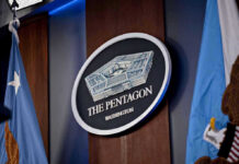 J6 Rioter Lands TOP Pentagon Job The Pentagon emblem between two flags.