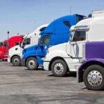 Child Left With Half a Skull After Illegal Truck Driver Crash! A lineup of colorful trucks parked in a lot