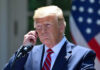 Federal Court Defies SCOTUS, Rules Trump Can’t Fire DEI Officers Man in a suit adjusting an earpiece.