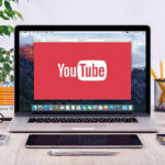 YouTubers Bring Down Massive Fraud Ring! YouTube logo on a laptop screen on desk.