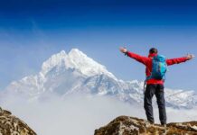 Hiker Impaled—Then Walked 10 Miles Hiker with arms raised facing snowy mountain peak