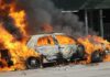Car Explosion Shreds Quiet Neighborhood Street A car engulfed in flames with thick smoke billowing into the air