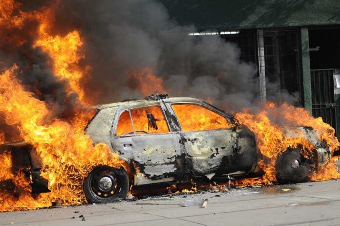 A,Burning,Car. A car engulfed in flames with thick smoke billowing into the air