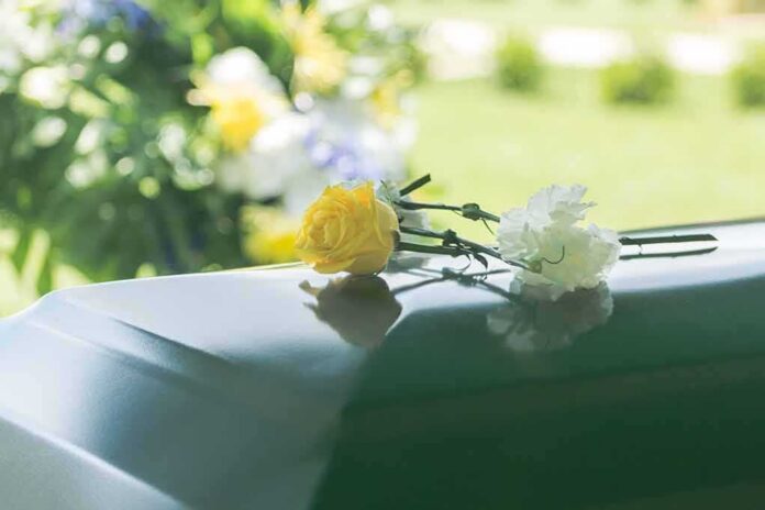 Yellow rose and white carnation on a green casket