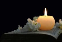 Hollywood Star and Congressman Passes Away Aged 84 Candle on an open book with white flowers