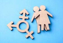 He Said “We Do Training, Not Trannies” Wooden transgender symbol and two human figures on blue background